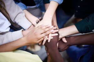 Visão de cima de um grupo de pessoas a meter as mãos ao centro